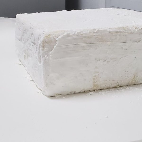 Bloque grande de queso fresco prensado y listo para su corte o maduración, mostrando la base de los quesos artesanales Juan Grande.